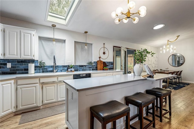 kitchen with hanging light fixtures, white cabinets, and a kitchen island