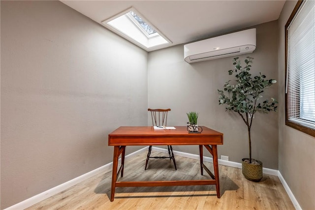 office area featuring hardwood / wood-style floors, a wall mounted AC, and a skylight