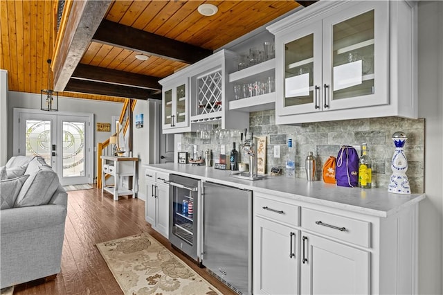 kitchen featuring tasteful backsplash, white cabinetry, beamed ceiling, beverage cooler, and dark hardwood / wood-style flooring