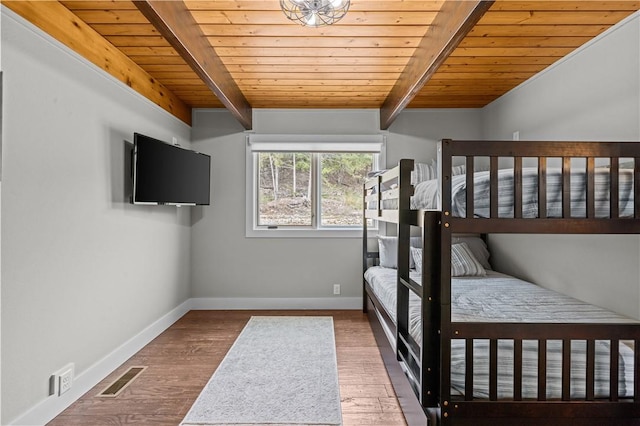 unfurnished bedroom with vaulted ceiling with beams, wood-type flooring, and wooden ceiling