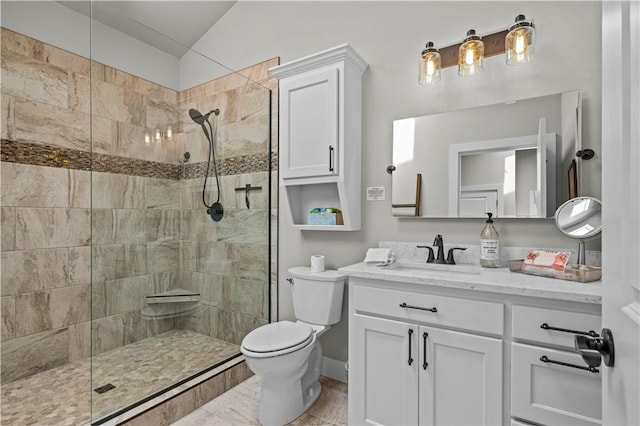 bathroom with vanity, a tile shower, and toilet