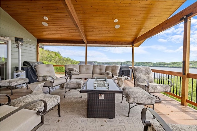 exterior space featuring a water view and an outdoor living space with a fire pit