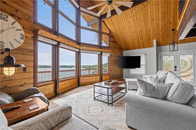 living room featuring ceiling fan, high vaulted ceiling, wooden ceiling, french doors, and wood walls