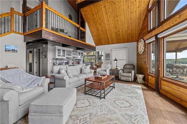 living room featuring hardwood / wood-style flooring, a healthy amount of sunlight, and a towering ceiling