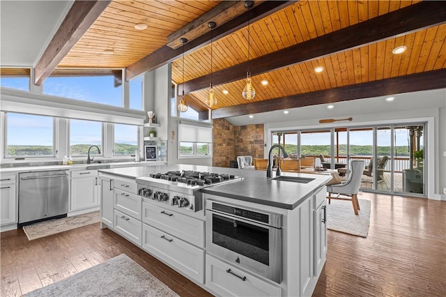 kitchen featuring sink, white cabinetry, decorative light fixtures, a center island with sink, and appliances with stainless steel finishes