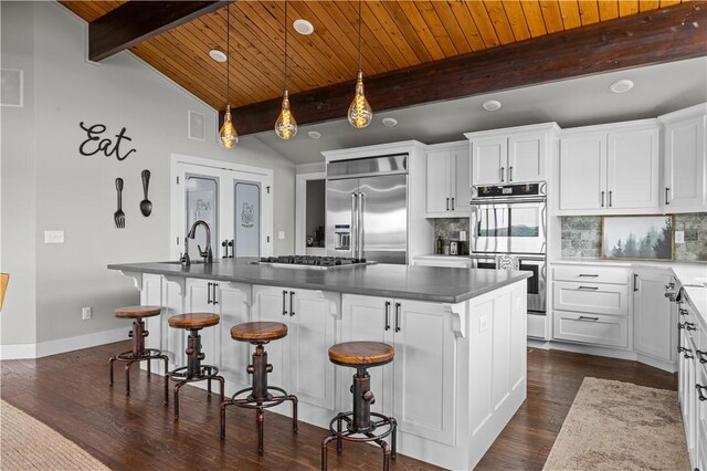 kitchen featuring white cabinetry, appliances with stainless steel finishes, and an island with sink