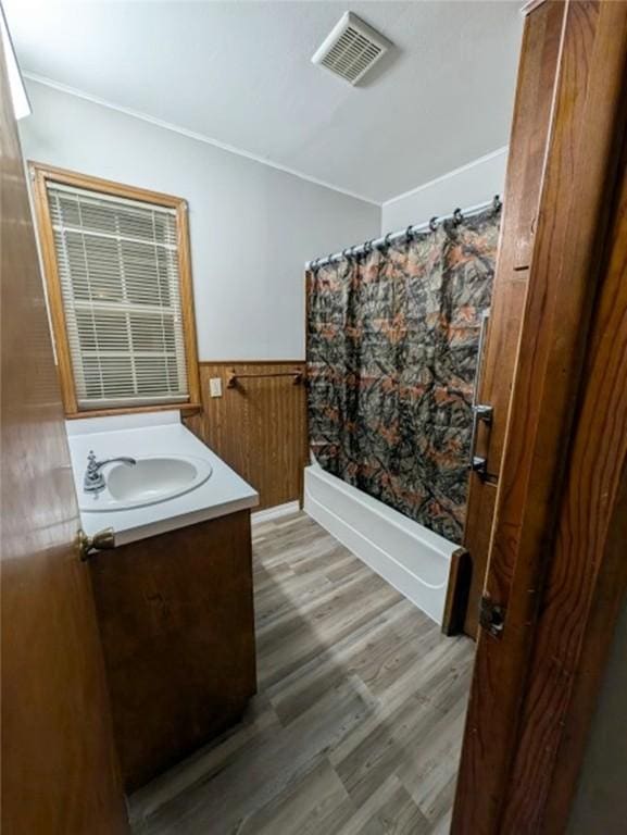 bathroom featuring hardwood / wood-style flooring, vanity, and shower / bath combo with shower curtain