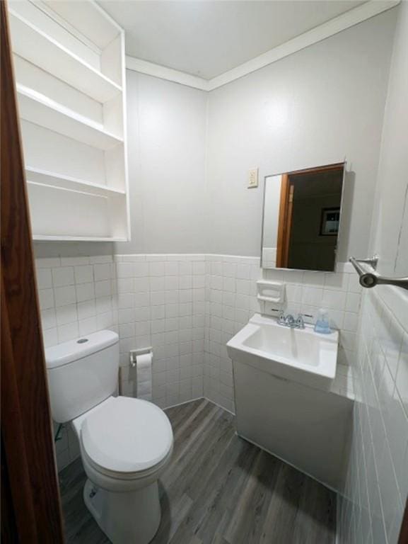 bathroom featuring hardwood / wood-style flooring, sink, tile walls, and toilet