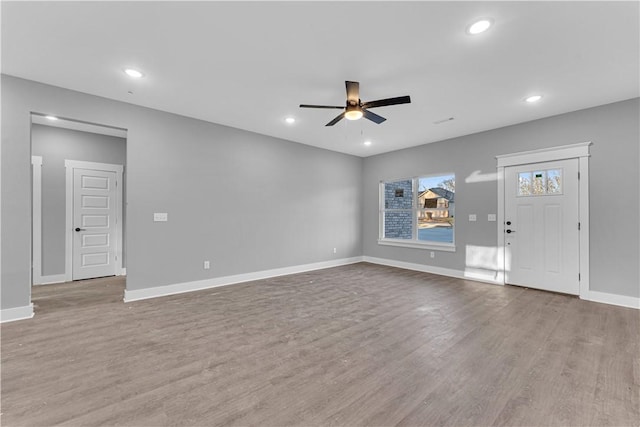 unfurnished living room with recessed lighting, baseboards, and wood finished floors
