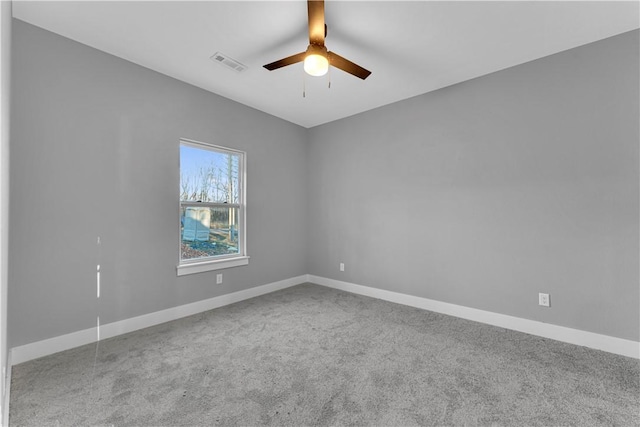 carpeted spare room featuring visible vents, ceiling fan, and baseboards