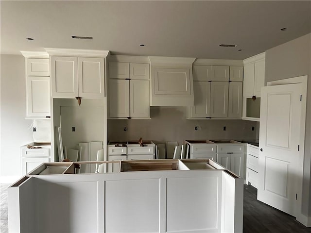 kitchen featuring dark hardwood / wood-style flooring, a center island, and white cabinets