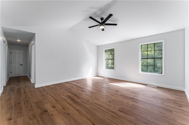 spare room featuring lofted ceiling, dark wood-type flooring, and ceiling fan