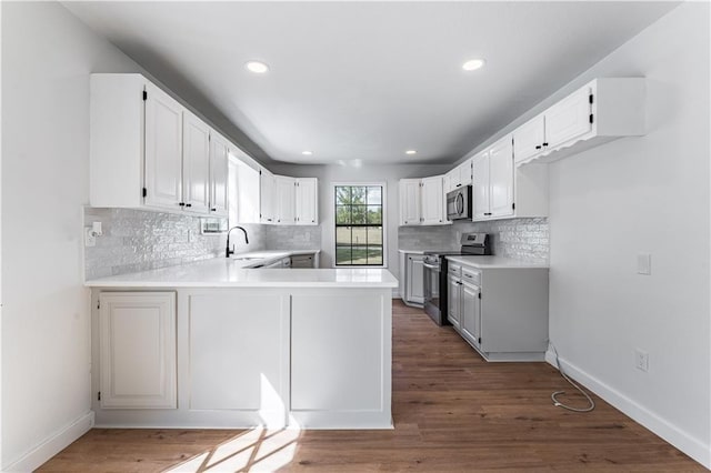 kitchen with white cabinetry, stainless steel appliances, and kitchen peninsula