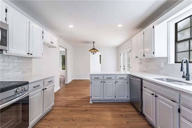 kitchen with white cabinetry, sink, pendant lighting, and appliances with stainless steel finishes