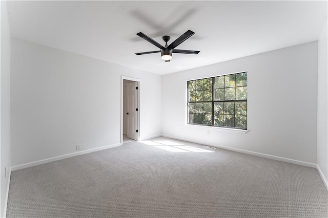 spare room with ceiling fan and light carpet