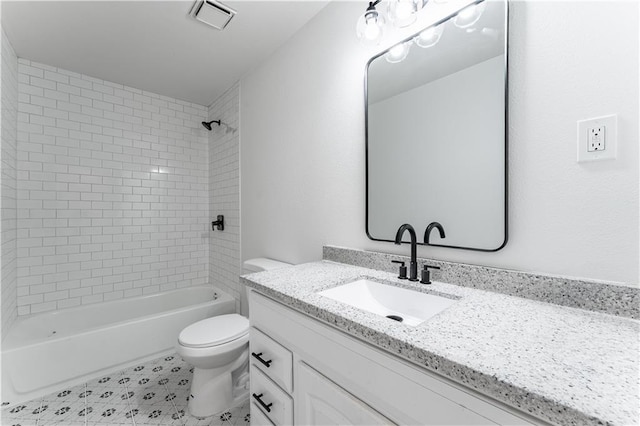 full bathroom featuring vanity, tiled shower / bath combo, and toilet