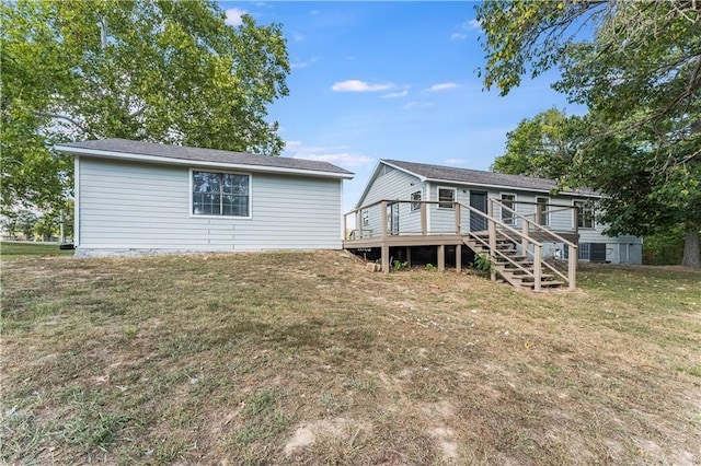 rear view of house with a yard and a deck