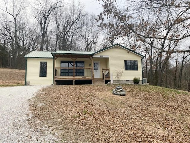 single story home featuring a porch, metal roof, driveway, and crawl space