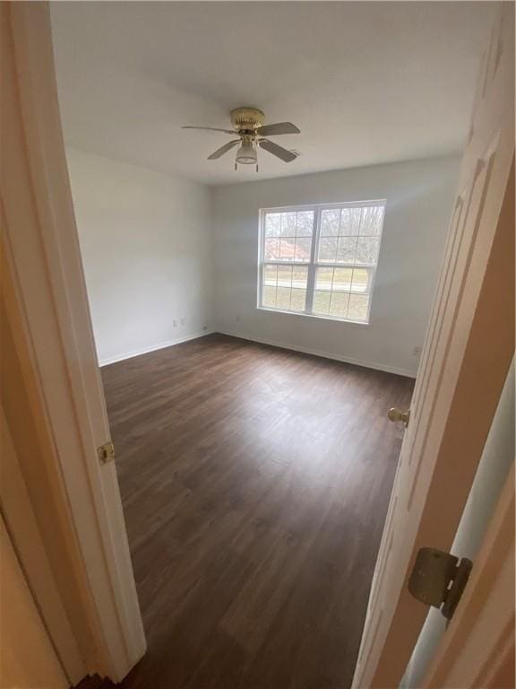 empty room with dark hardwood / wood-style floors and ceiling fan