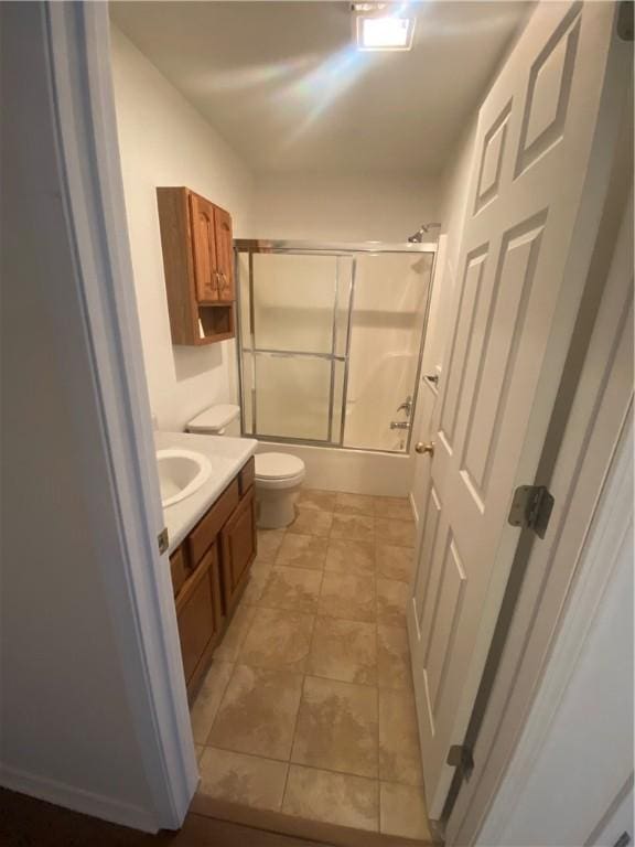 full bathroom featuring bath / shower combo with glass door, vanity, and toilet