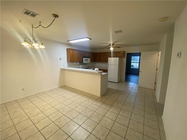 kitchen featuring white appliances, kitchen peninsula, ceiling fan with notable chandelier, and light tile patterned floors