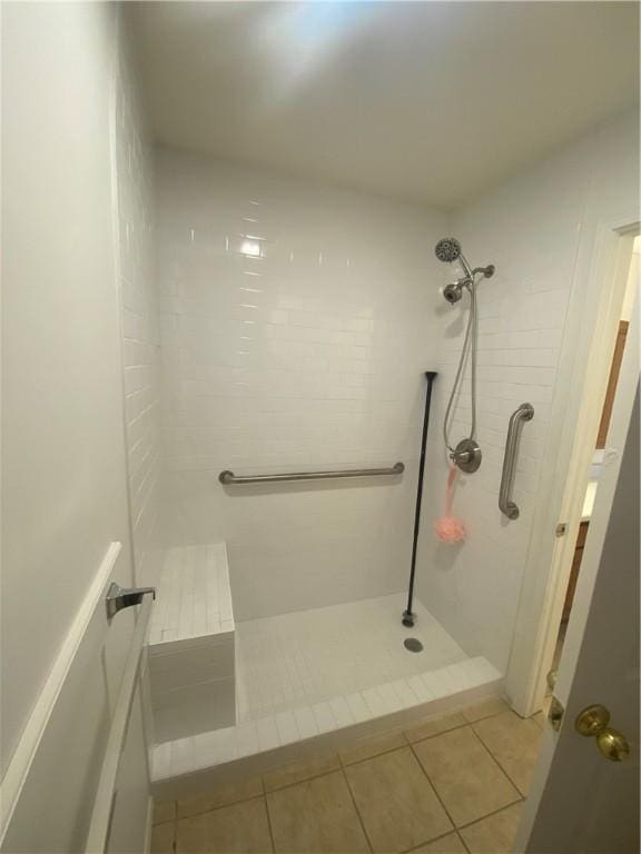 bathroom featuring tile patterned flooring and a tile shower