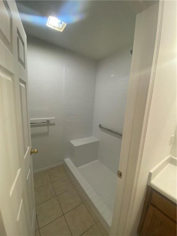 bathroom featuring tile patterned flooring, vanity, and walk in shower