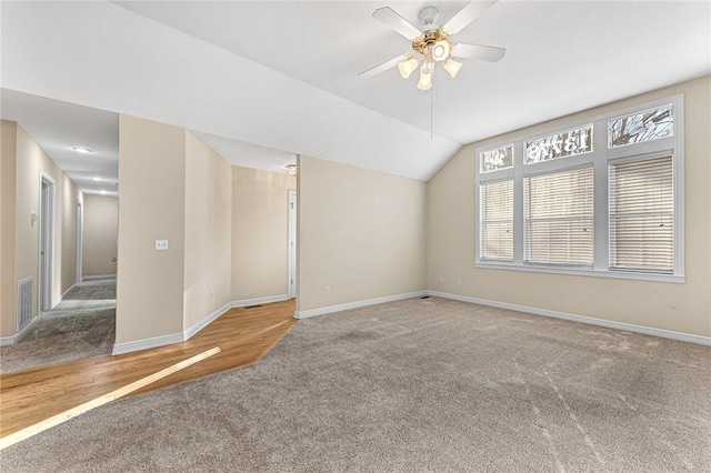 carpeted empty room with ceiling fan and lofted ceiling