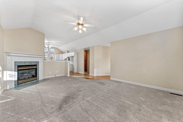 unfurnished living room featuring lofted ceiling, light carpet, a premium fireplace, and ceiling fan