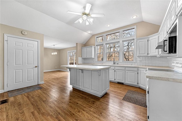 kitchen with decorative light fixtures, a center island, and white cabinets