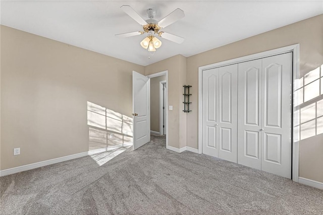 unfurnished bedroom with light colored carpet, a closet, and ceiling fan