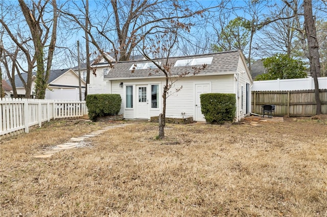 rear view of house featuring a lawn