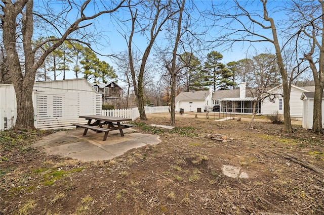 view of yard with an outdoor structure, a sunroom, and a patio