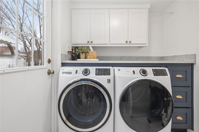 laundry room featuring cabinets, separate washer and dryer, and plenty of natural light