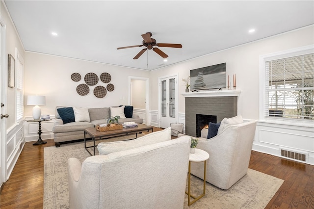 living room with ceiling fan, dark hardwood / wood-style floors, and a brick fireplace