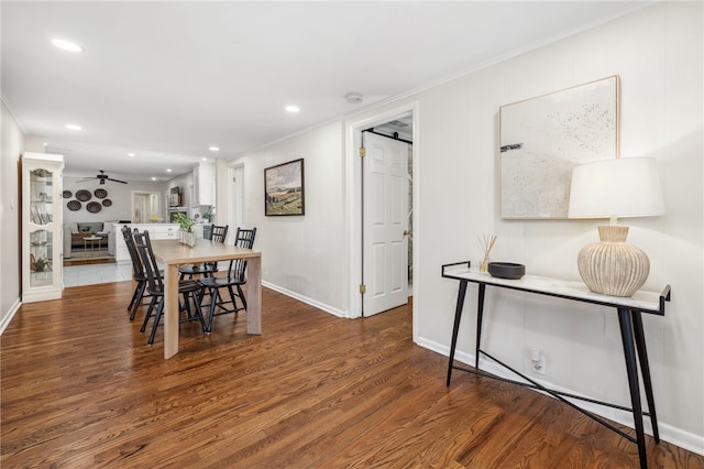 dining space featuring hardwood / wood-style flooring, crown molding, a barn door, and ceiling fan