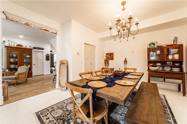 dining space featuring a notable chandelier and light wood-type flooring