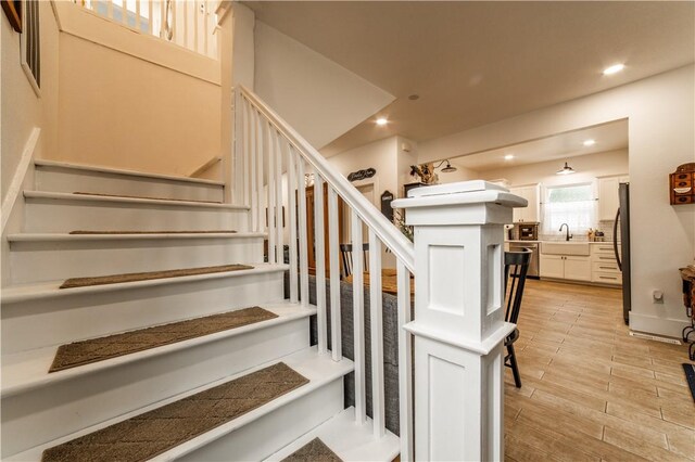 stairway featuring hardwood / wood-style flooring and sink