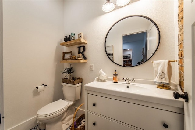 bathroom with vanity, baseboards, and toilet