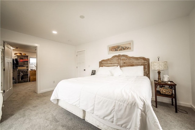 bedroom with a closet, recessed lighting, light colored carpet, and baseboards