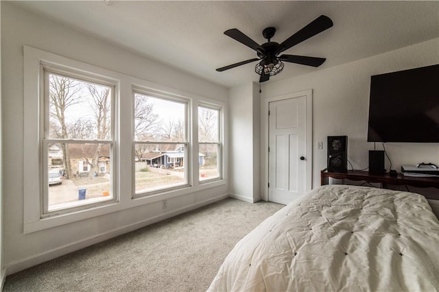 carpeted bedroom featuring baseboards and a ceiling fan