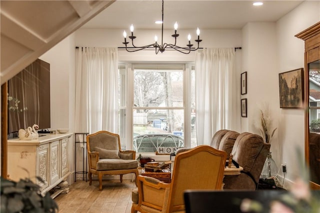 living area featuring recessed lighting, light wood-style flooring, and an inviting chandelier
