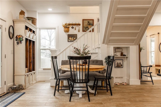 dining space with wood finished floors, recessed lighting, and stairway