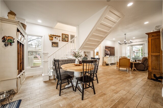 dining space with an inviting chandelier and light hardwood / wood-style flooring