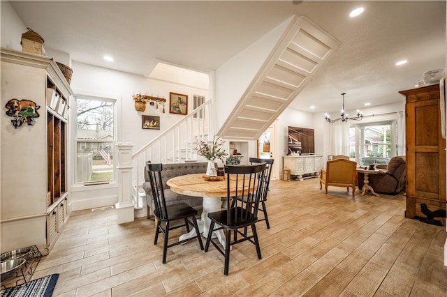 dining space with a chandelier, light wood-style floors, recessed lighting, and stairs