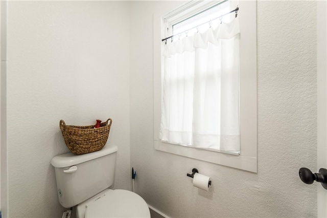 bathroom with a textured wall and toilet