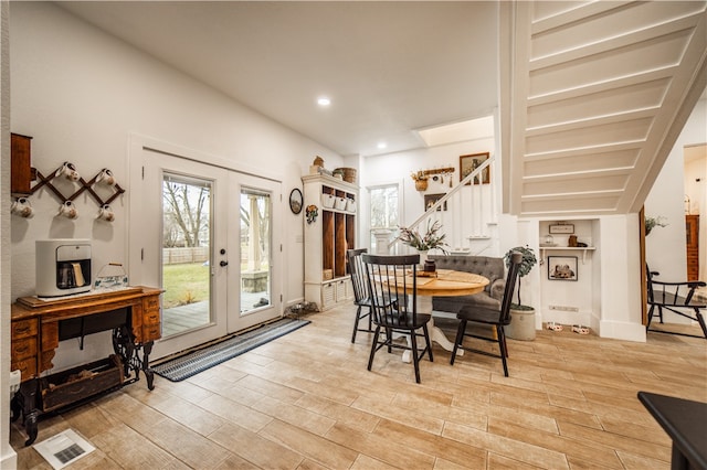 dining space with french doors and light hardwood / wood-style flooring