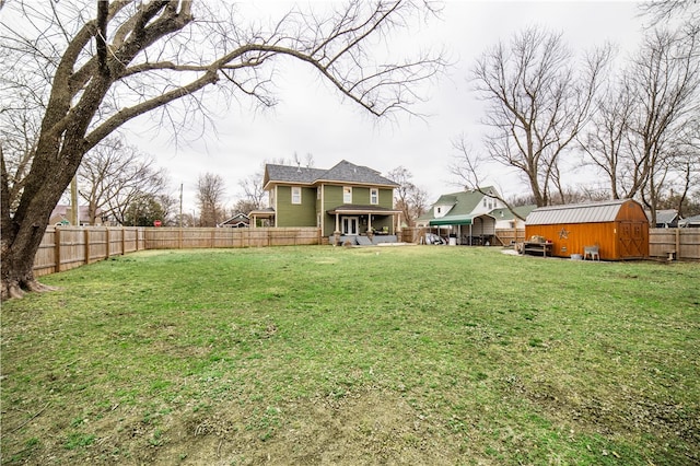 view of yard featuring a fenced backyard, a storage unit, and an outdoor structure