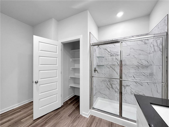 bathroom featuring a shower with door, vanity, and hardwood / wood-style flooring