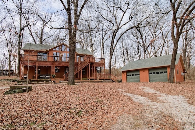 exterior space featuring a wooden deck, a garage, and an outbuilding